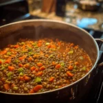 A bowl of spicy lentil soup garnished with fresh herbs and spices