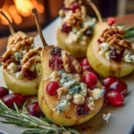 Baked pears with Brie cheese, walnuts, and cranberries on a serving plate.