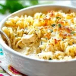 Delicious Chicken Alfredo casserole topped with cheese and herbs