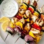 Greek Chicken Skewers with herbs and spices on a grill plate